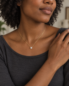 Illustrative portrait of a model with dark skin wearing the Lumière pendant